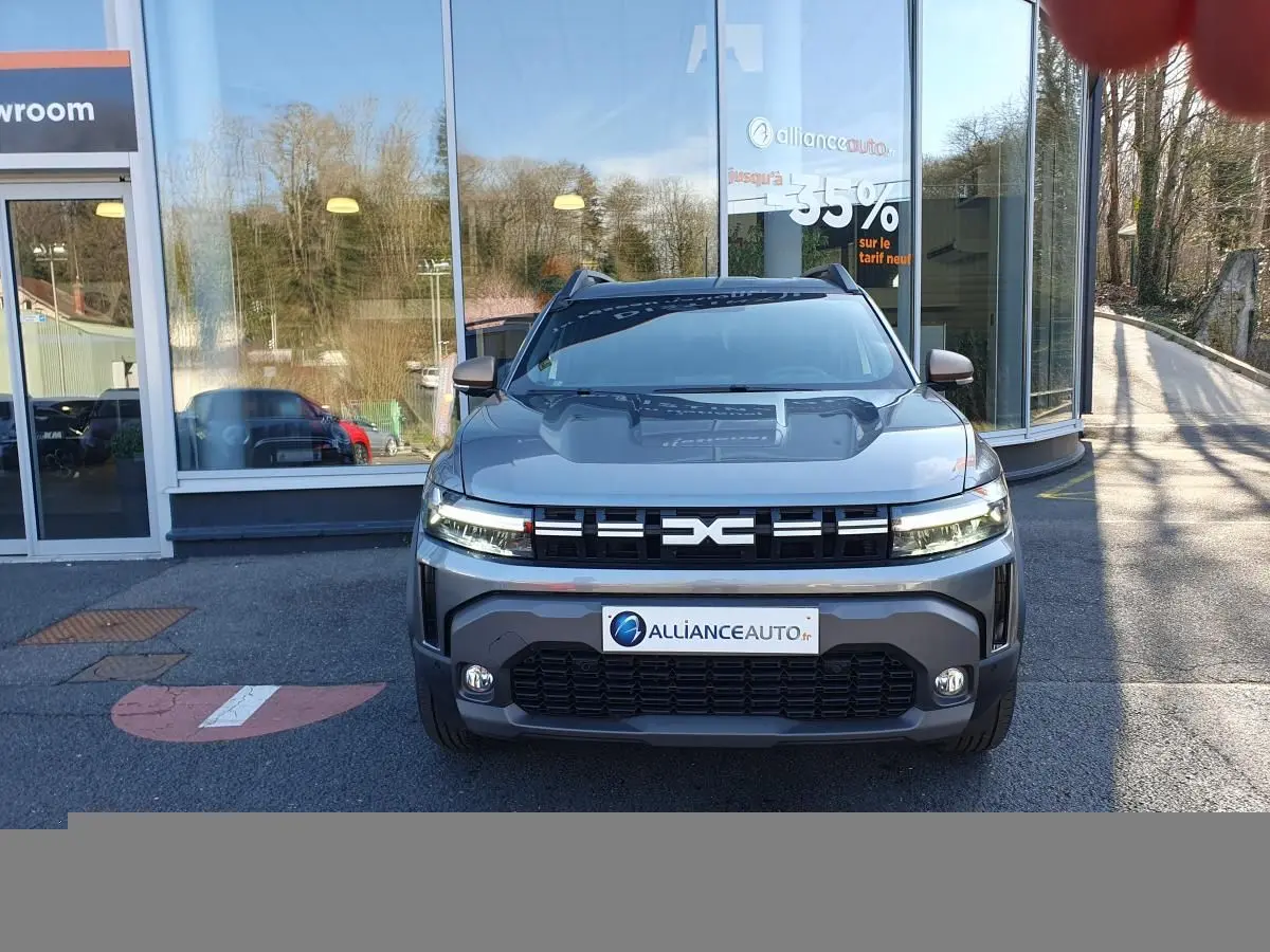 Vue frontale du Dacia Duster 1.6 Hybrid gris schiste, avec signature lumineuse LED et calandre marquée EXC.