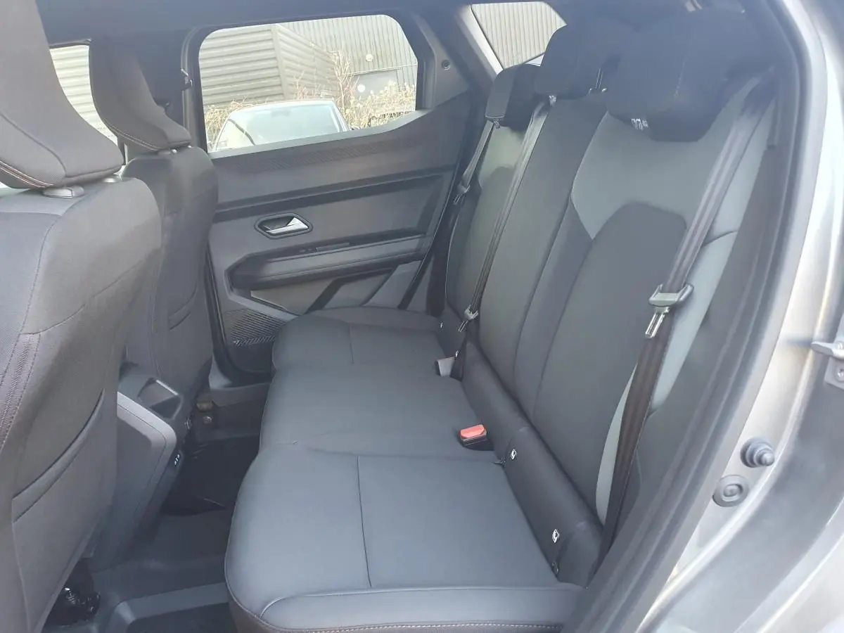 Vue intérieure côté droit sur la banquette arrière noire du Dacia Duster gris schiste 2026, finition hybride.