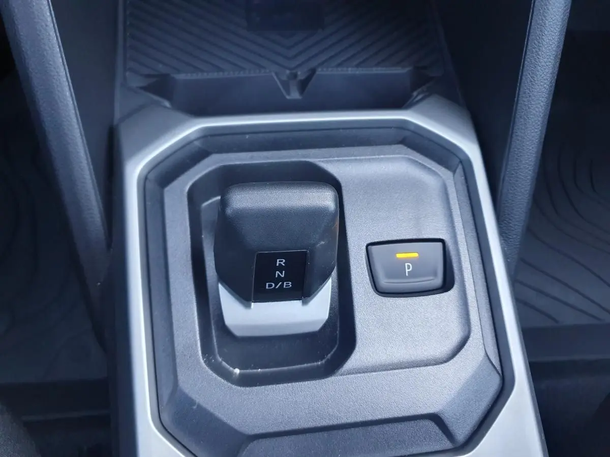 Gros plan sur la commande de boîte automatique noire et grise du Dacia Duster gris schiste, avec bouton de parking éclairé.