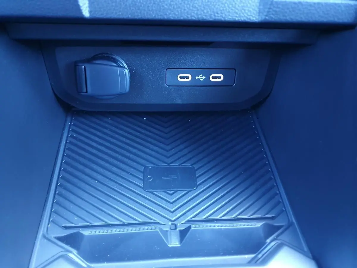 Vue rapprochée de la console centrale du Dacia Duster 2026, montrant les ports USB et un espace de recharge sans fil.