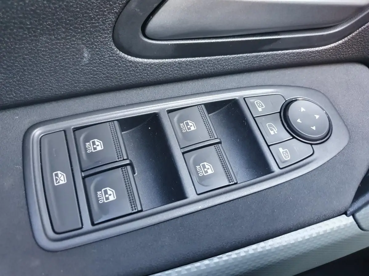 Panneau de commandes des vitres électriques et rétroviseurs côté gauche intérieur du Dacia Duster gris schiste.