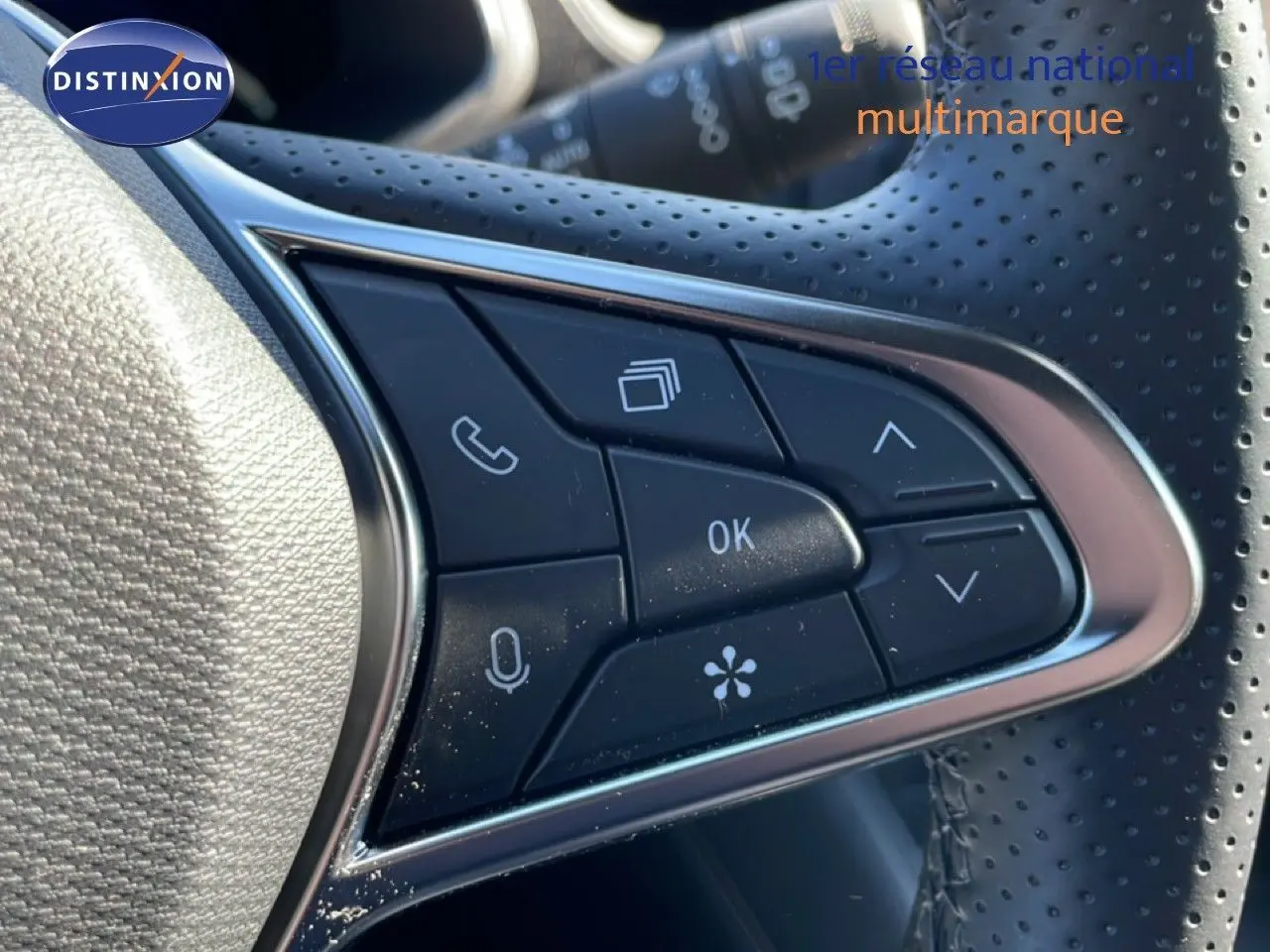 Gros plan sur les commandes multifonctions du volant perforé d’une Renault Symbioz noire étoile métal, version 2025.