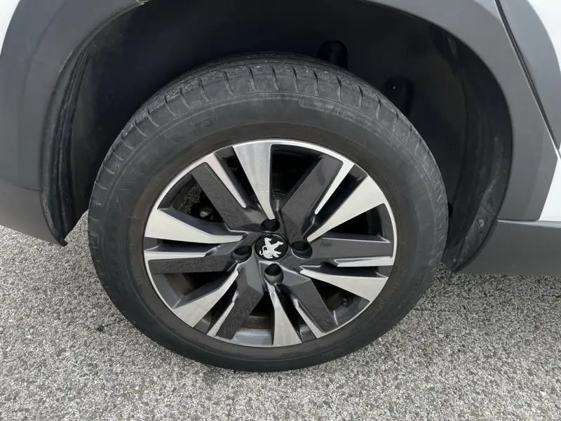 Gros plan sur la roue avant droite du Peugeot 2008 blanc de 2019 avec jante alliage au design moderne.