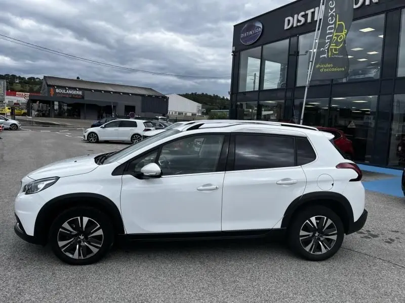 Vue de profil côté gauche d'un Peugeot 2008 blanc de 2019, version 1.2 Puretech 130 allure avec jantes alliage et toit noir.