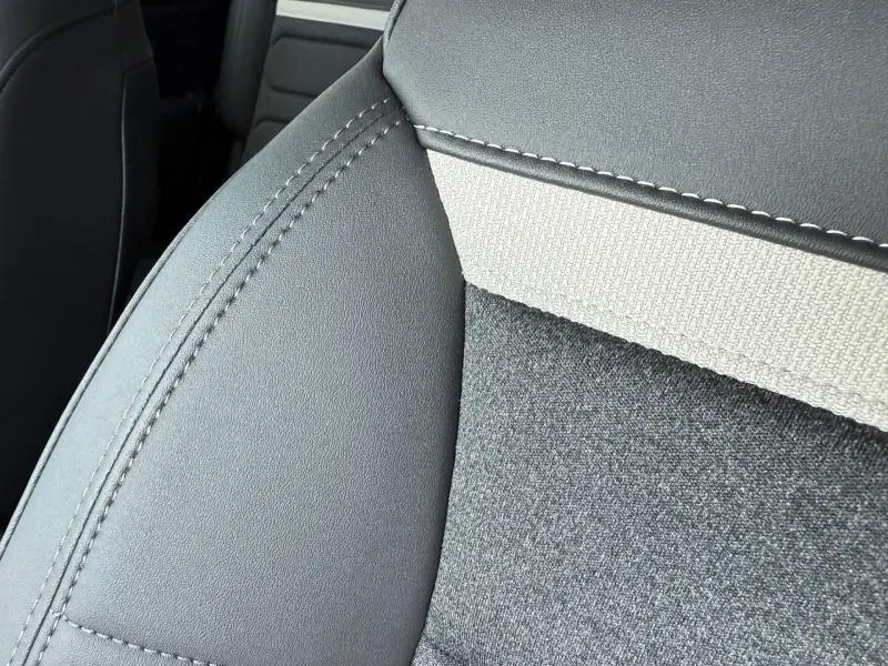 Détail du siège avant gris clair et tissu texturé du Citroën C5 Aircross hybride 2025, vue rapprochée intérieure.