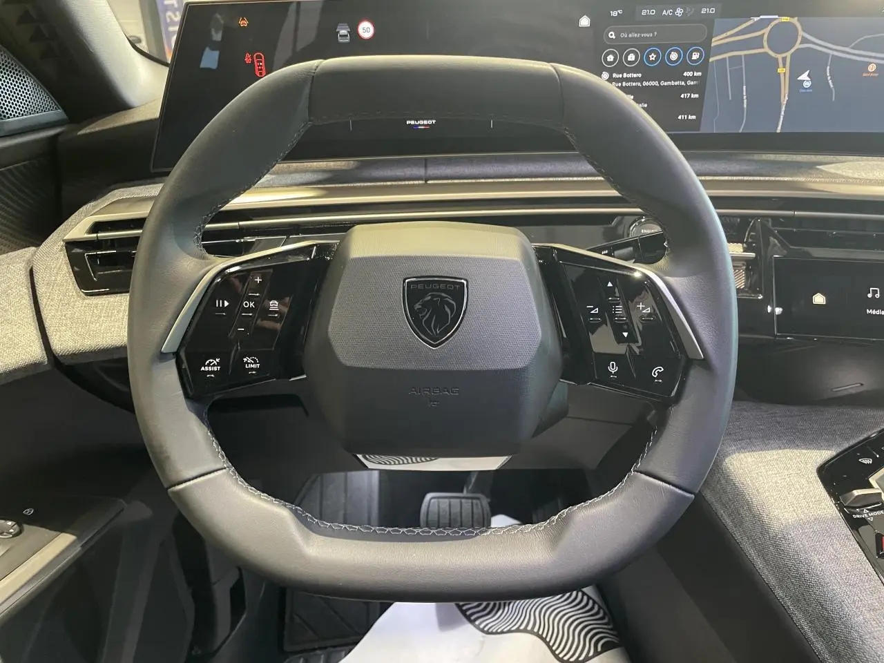 Vue rapprochée du volant cuir noir du Peugeot 3008 2025 avec commandes intégrées et tableau de bord numérique panoramique.