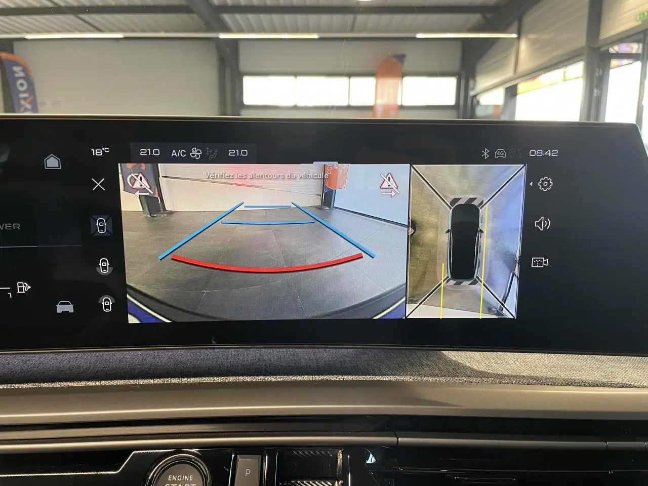 Vue de l'écran intérieur du Peugeot 3008 affichant la caméra de recul et la vue 360° du véhicule en stationnement.