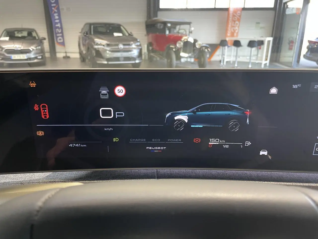 Vue intérieure du tableau de bord numérique du Peugeot 3008 gris foncé, affichant l'état hybride et la distance restante.