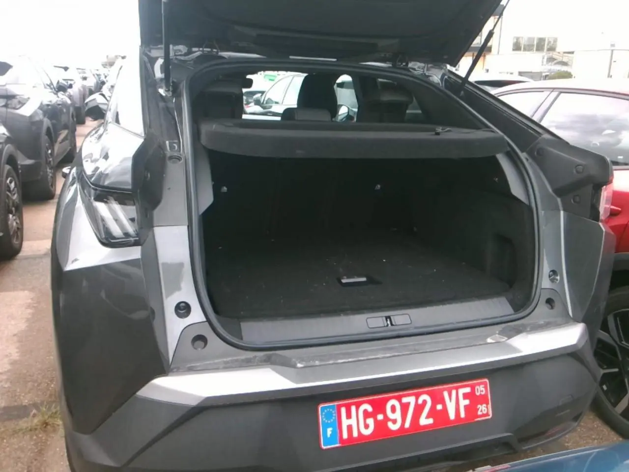 Vue arrière ouverte du Peugeot 3008 gris foncé 2025, mettant en valeur le coffre spacieux et la finition métallique.