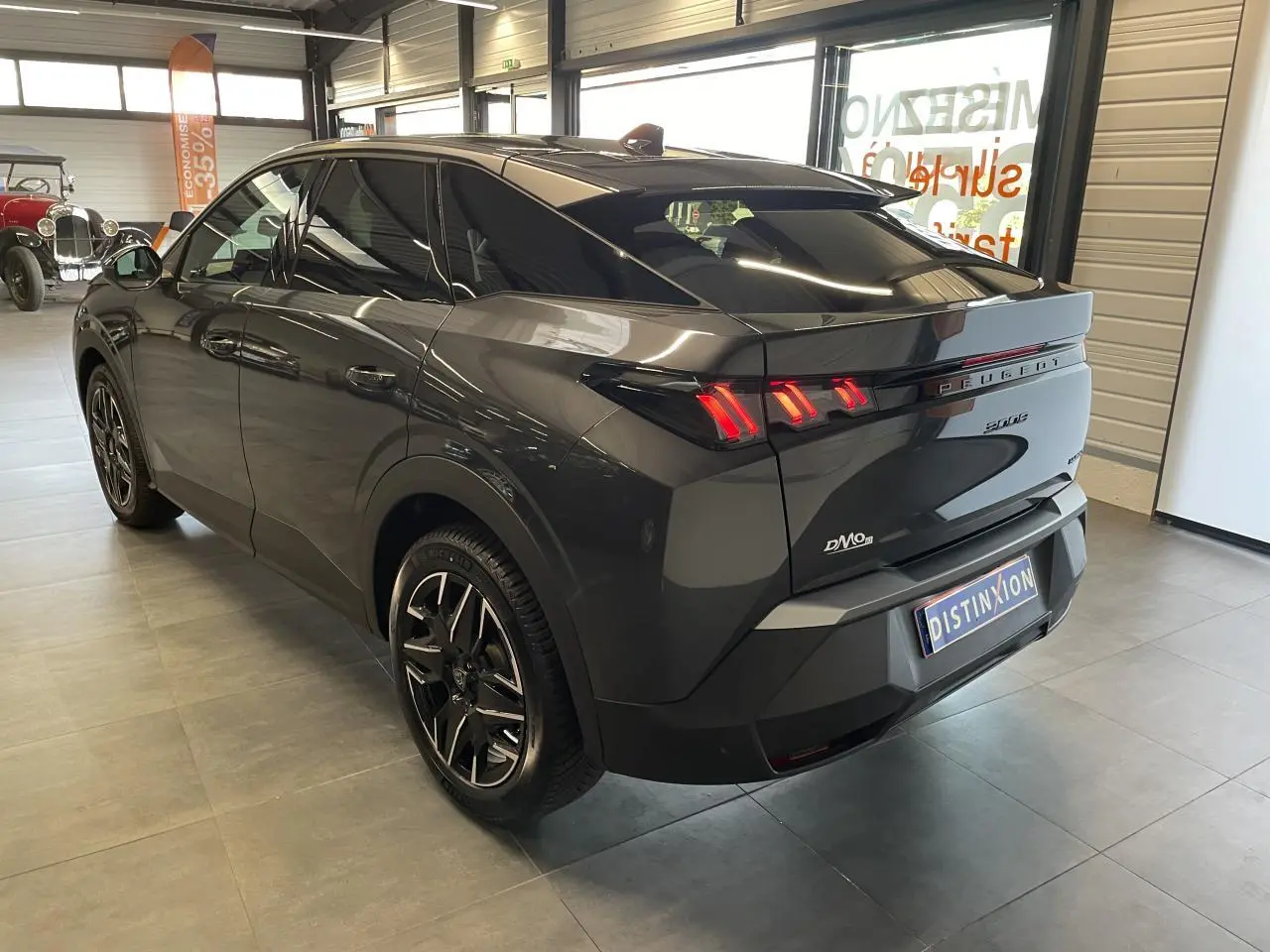 Vue 3/4 arrière droite d'un Peugeot 3008 gris foncé avec feux arrière LED 3 griffes et jantes alliage 19'' diamantées.