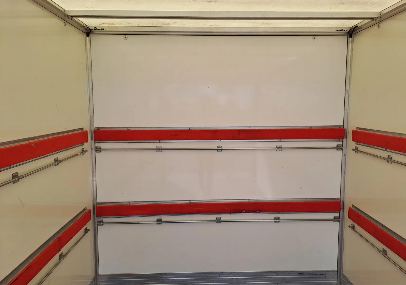 Vue intérieure de la caisse blanche du Nissan Interstar Chassis Cabine 2024, avec rails et protections rouges sur les parois.
