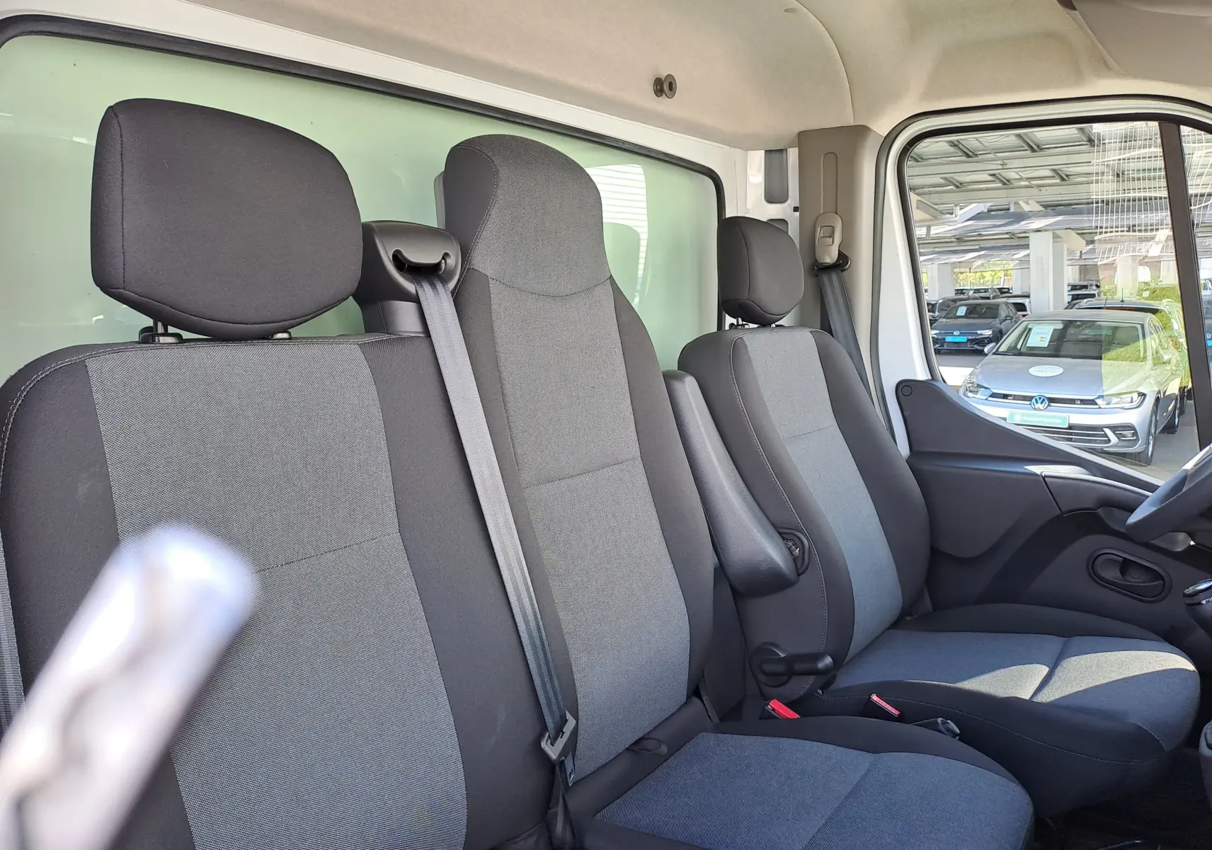 Vue intérieure côté droit du Nissan Interstar Châssis Cabine 2024, montrant les sièges gris et noir avec ceinture de sécurité.