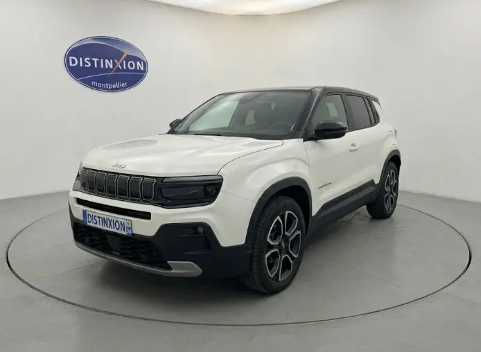 Jeep Avenger blanc en 3/4 avant droit, toit noir contrasté et calandre noire distinctive, version Summit 2025.