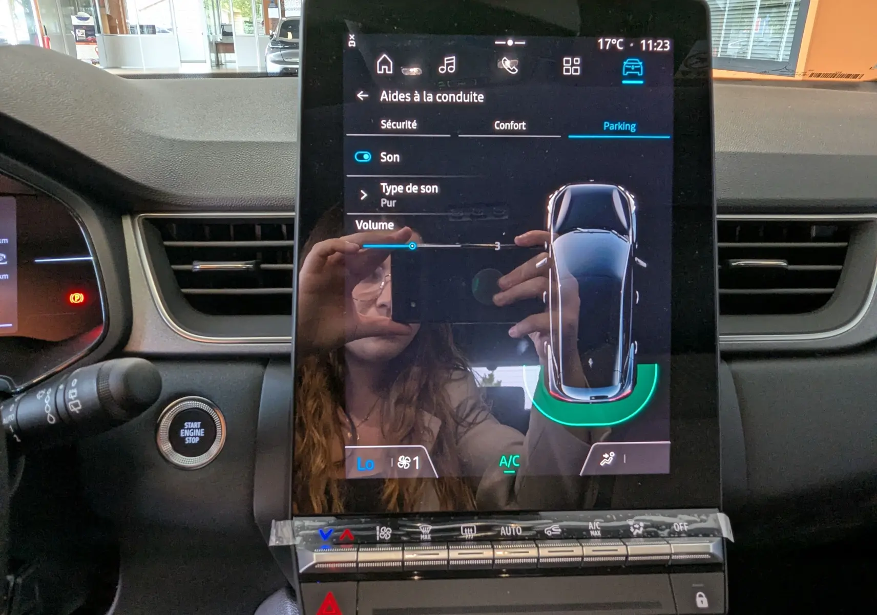 Écran tactile central du tableau de bord du Renault Captur blanc nacré, affichant les aides à la conduite en mode parking.