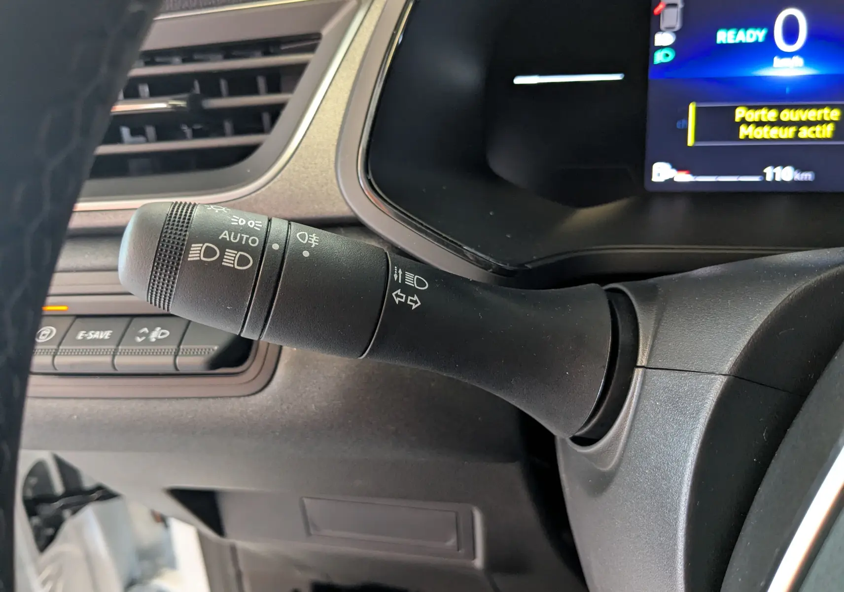 Gros plan sur la commande des phares et clignotants à gauche du volant du Renault Captur blanc nacré 2025.