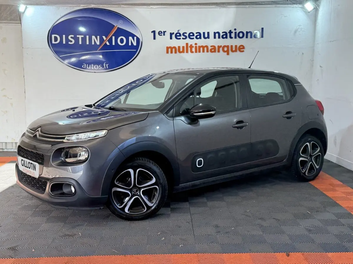 Citroën C3 gris clair vue 3/4 avant droit avec protections latérales Airbump et jantes noires dessinées.