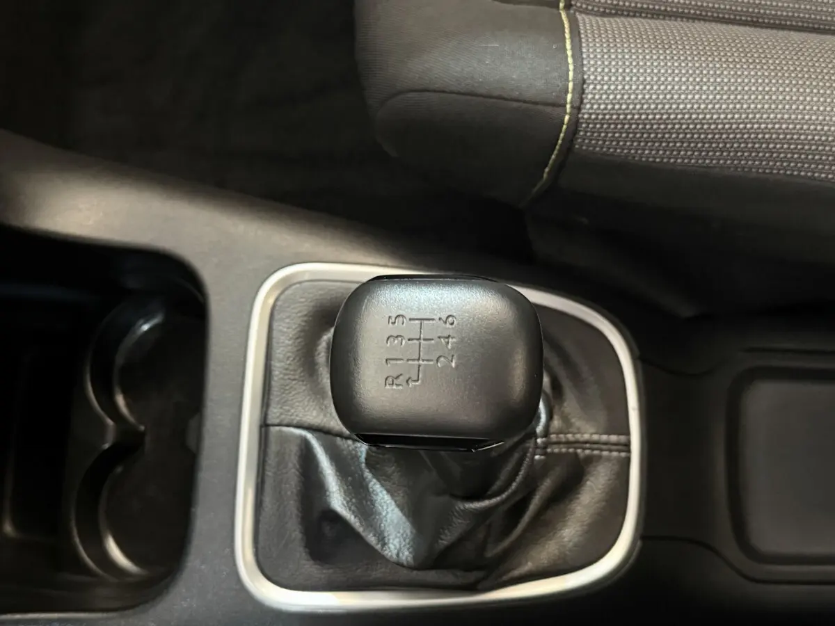 Le levier de vitesses manuel noir de la Citroën C3 2019, vu de dessus avec sellerie grise à coutures jaunes.