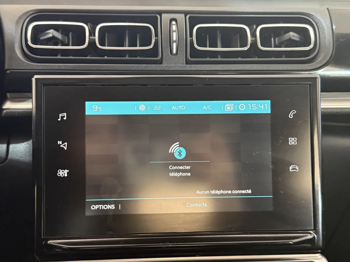 Écran tactile central allumé avec interface Bluetooth dans l'habitacle noir d'une Citroën C3 gris clair.
