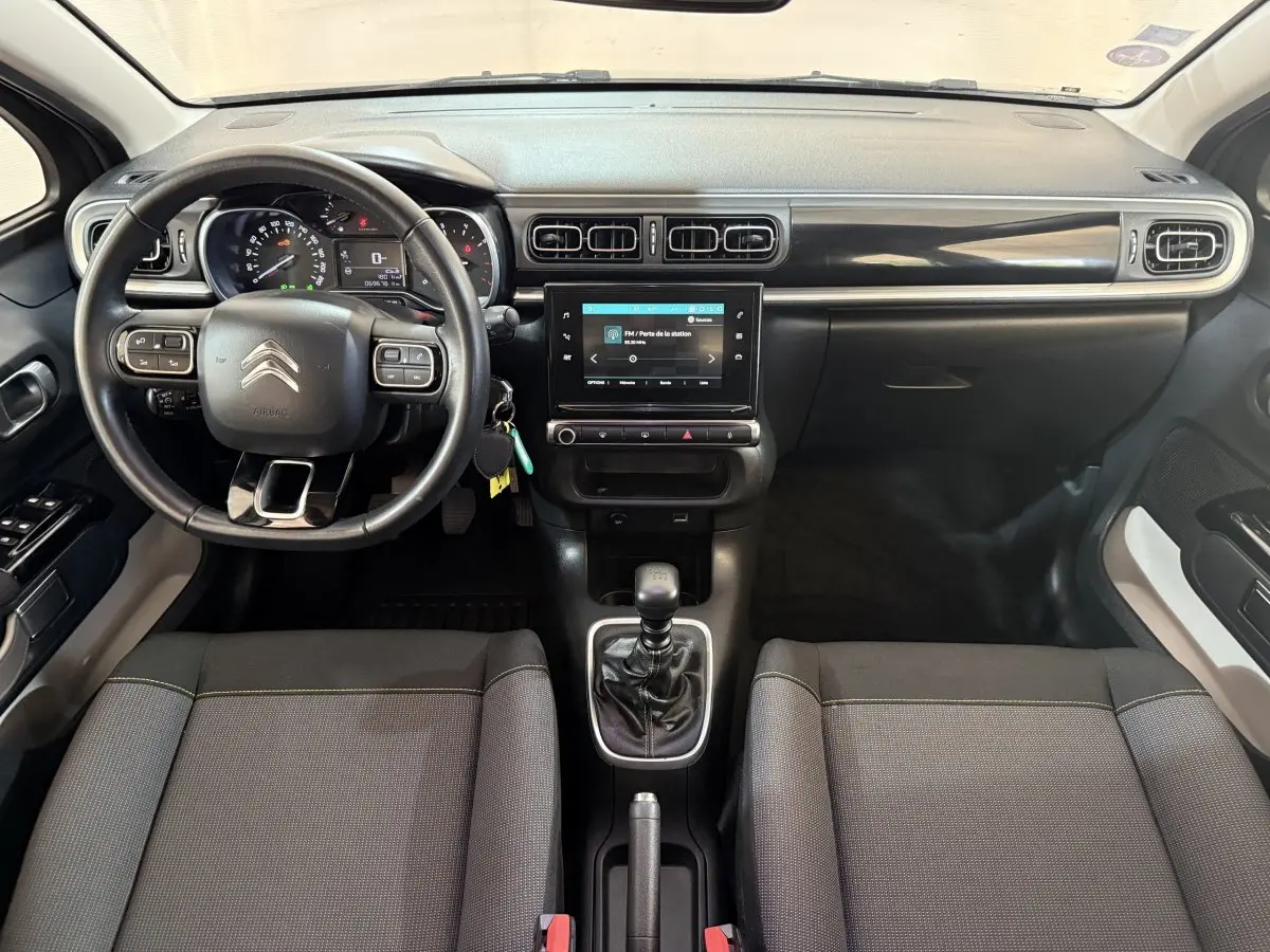 Intérieur de Citroën C3 gris clair, vue frontale du tableau de bord avec écran tactile et volant multifonctions.