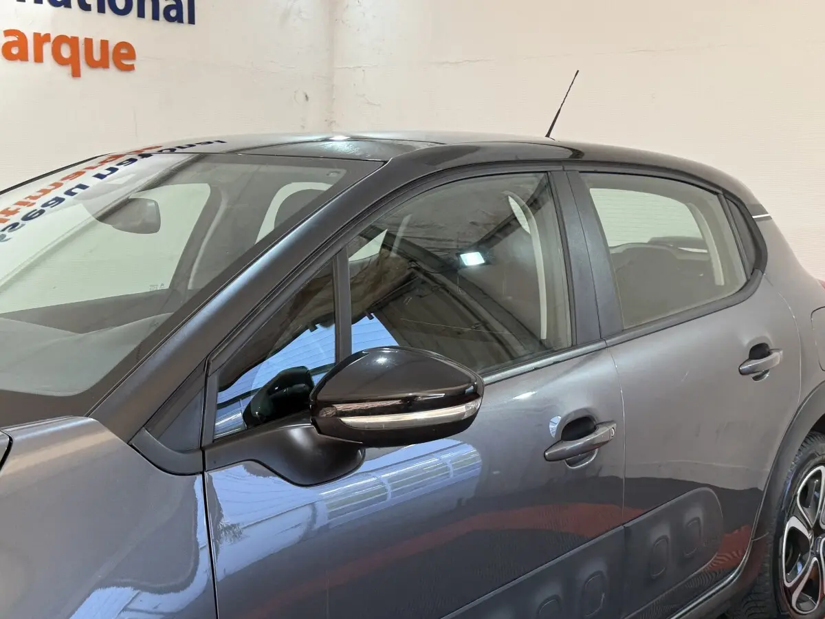 Profil côté gauche d'une Citroën C3 gris clair 2019 avec protections latérales noires et rétroviseur ton caisse.