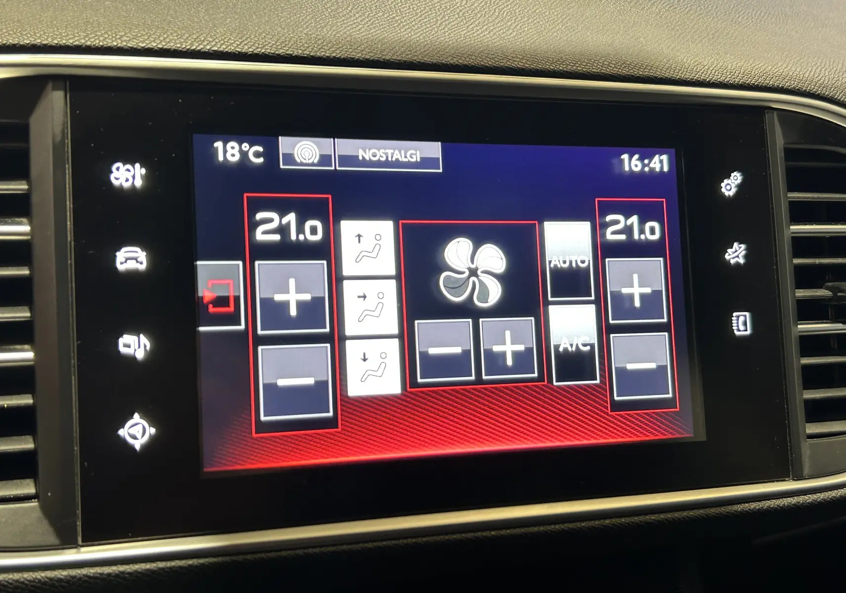 Écran tactile central du tableau de bord de la Peugeot 308 noir, affichant la climatisation réglée à 21°C côté conducteur et passager.