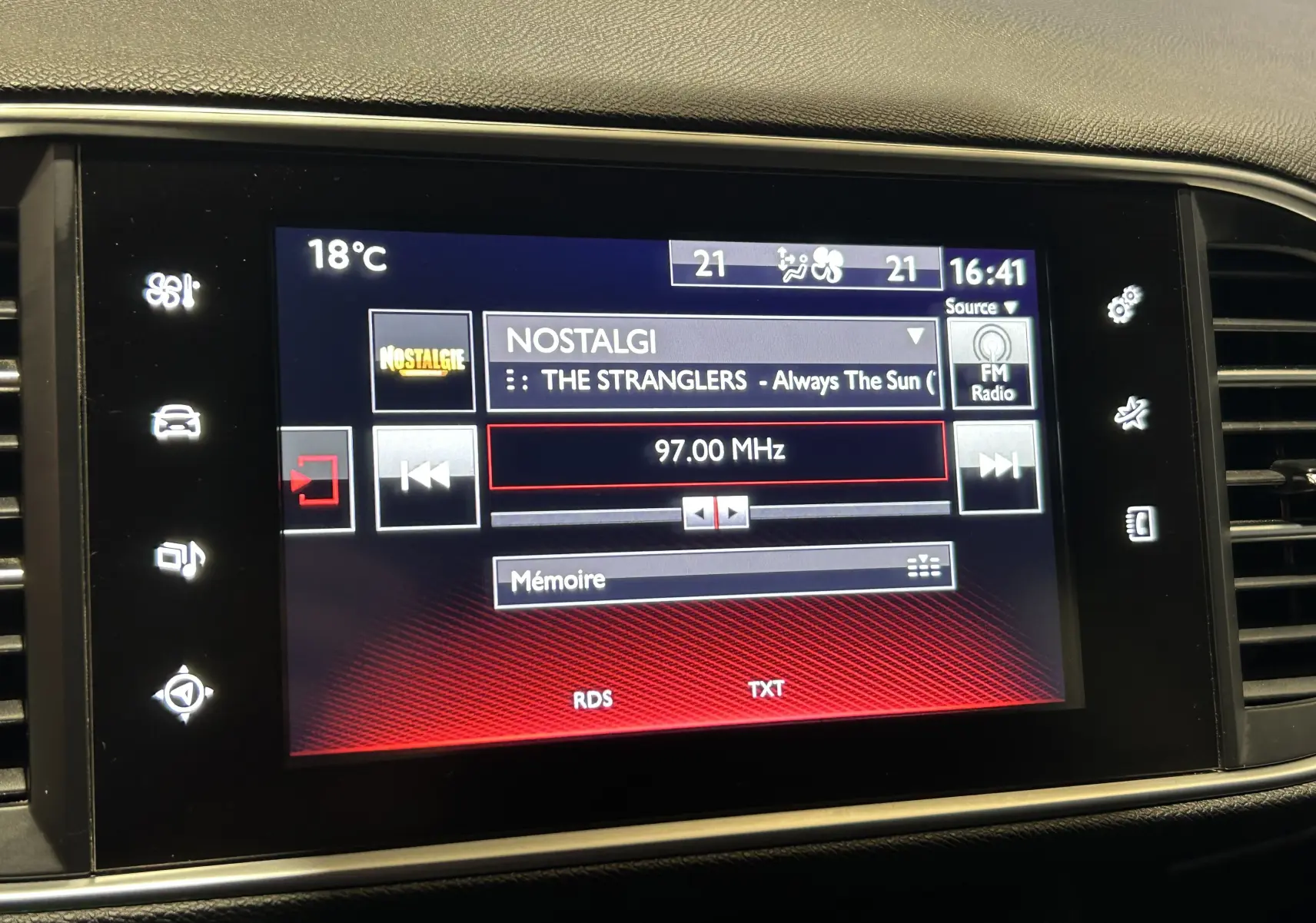 Écran tactile central de la Peugeot 308 noir, affichant la radio FM sur la station Nostalgie à 97 MHz.