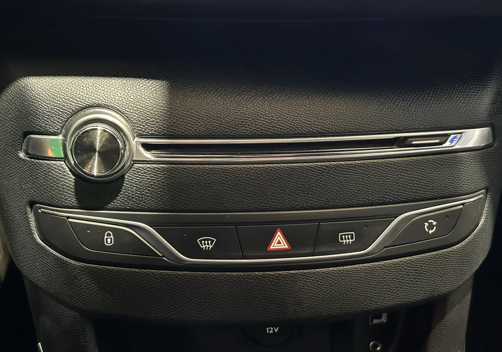 Gros plan sur la console centrale noire de la Peugeot 308 GT Line 2017, avec boutons de verrouillage, hazard et recyclage d'air.