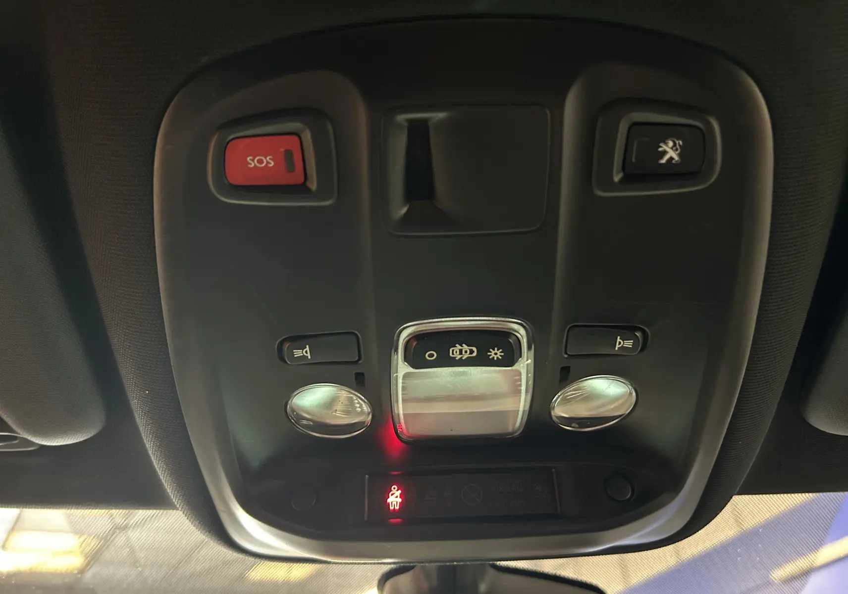 Vue intérieure en gros plan du plafonnier noir avec boutons SOS et ouverture coffre sur Peugeot 308 2017.