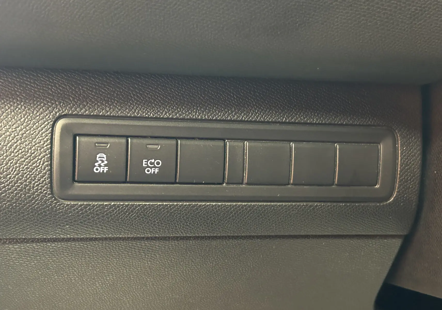 Gros plan sur les boutons de commande du tableau de bord noir de la Peugeot 308 GT Line 2017, avec fonctions ABS et ECO off.