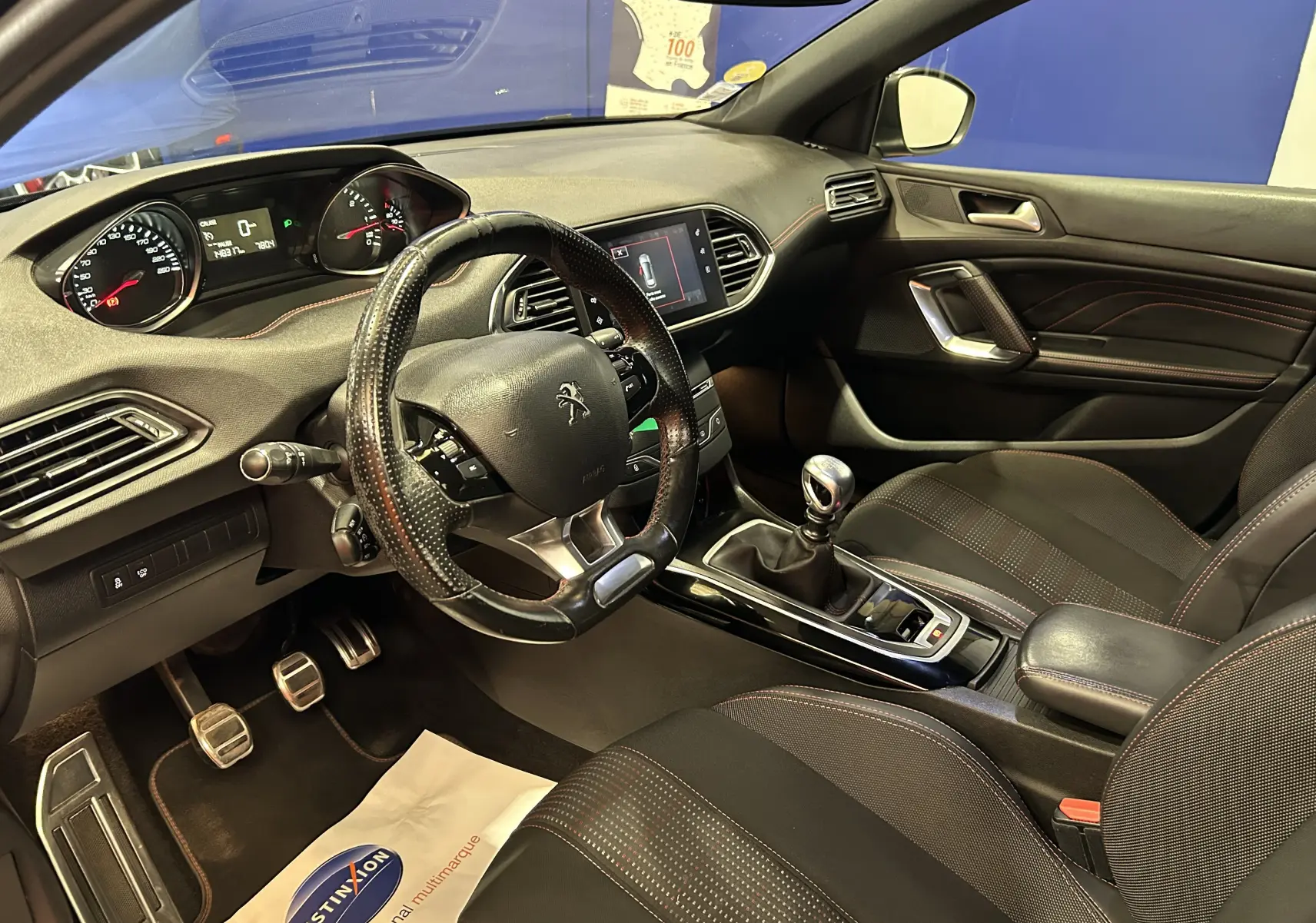 Intérieur noir de la Peugeot 308 GT Line 2017, vue côté conducteur montrant volant cuir, tableau de bord et levier de vitesse manuel.