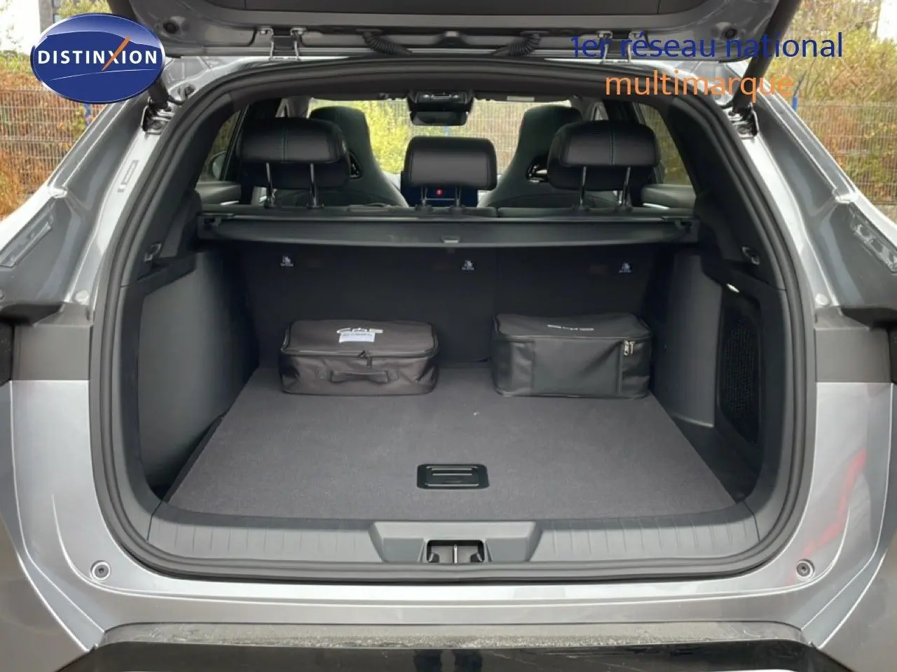 Coffre ouvert vu de l'arrière d'un BYD SEAL U gris Time Grey Metal avec deux sacs de rangement à l'intérieur.