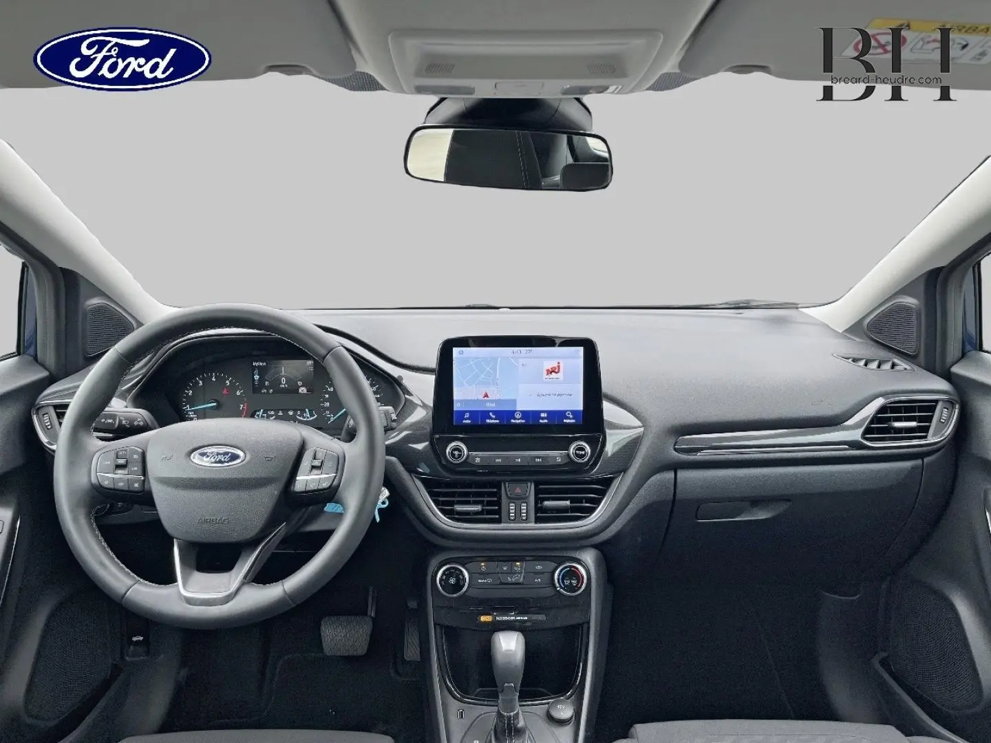 Vue intérieure avant du Ford Puma 2023 bleu, montrant le volant multifonction et l’écran tactile central.
