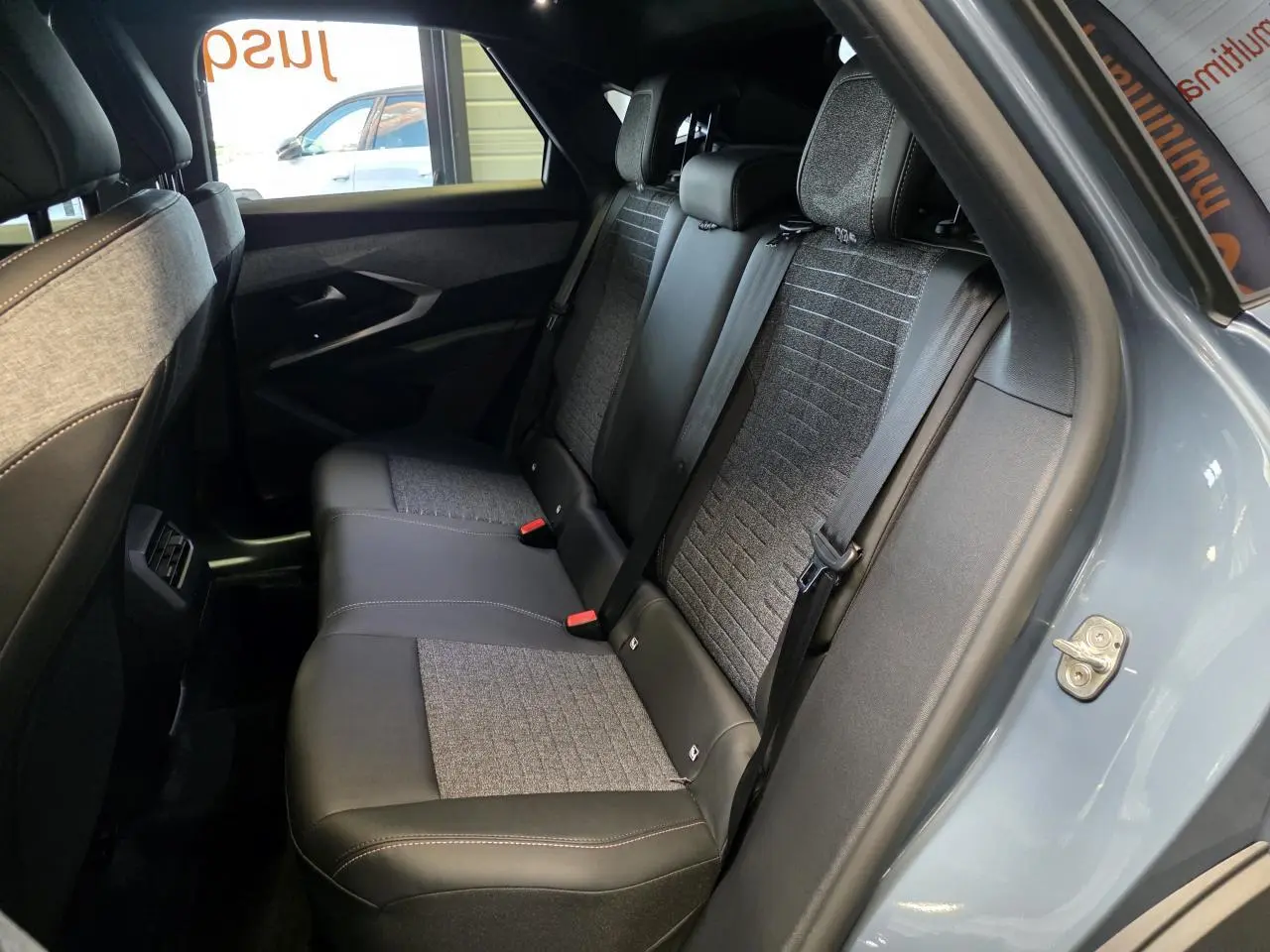 Vue intérieure côté droit sur la banquette arrière du Peugeot 3008 2025 en bleu clair avec sellerie mixte tissu et cuir.