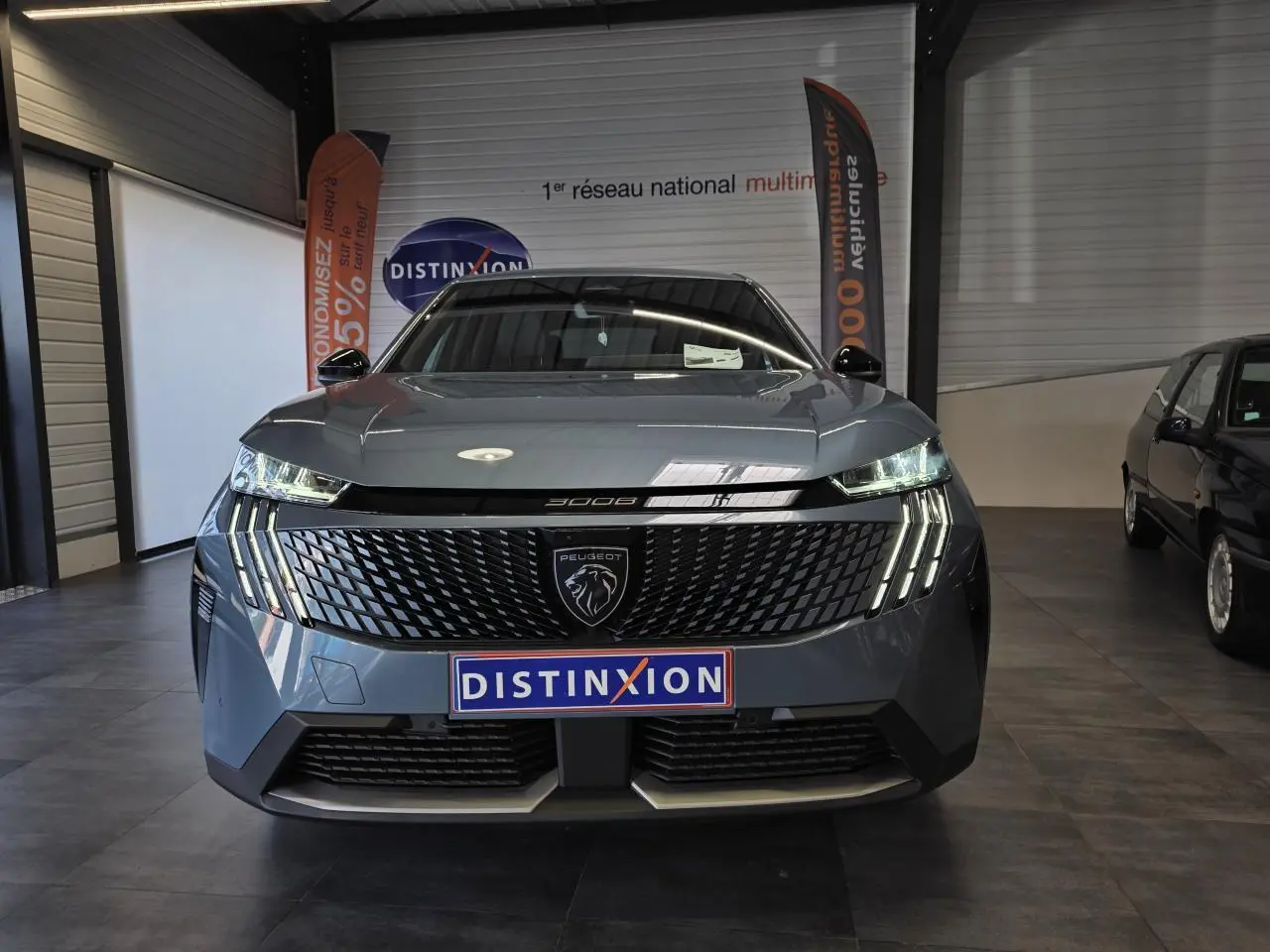 Vue avant frontale du Peugeot 3008 2025 bleu clair avec calandre noire et feux LED à griffes distinctifs.