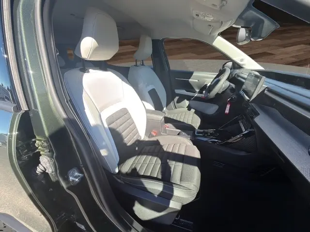 Vue intérieure côté conducteur du Citroën C3 Aircross vert 2026, montrant sièges bicolores et tableau de bord moderne avec écran tactile.