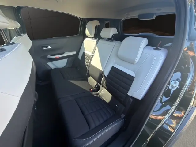 Vue intérieure côté droit sur la banquette arrière bicolore noire et blanche du Citroën C3 Aircross hybride 2026.