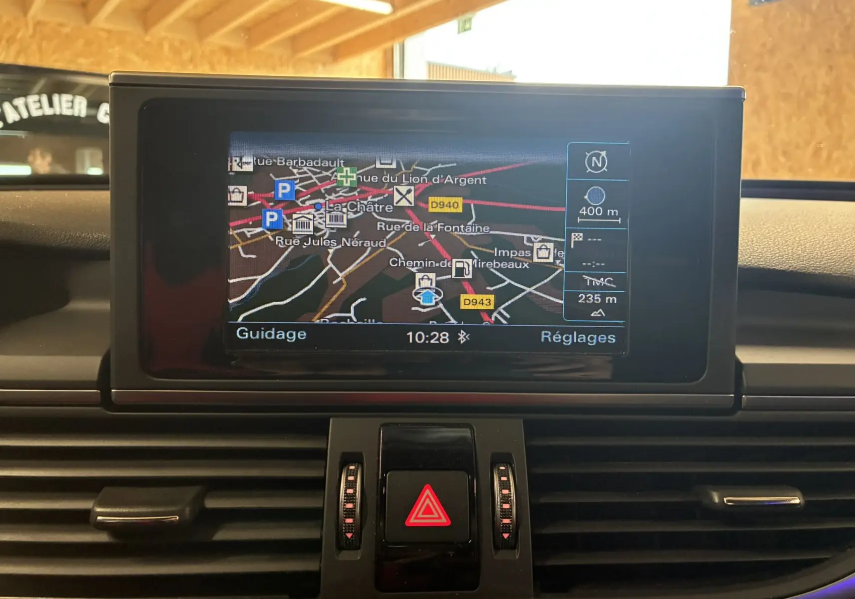 Écran de navigation central affichant une carte dans l'habitacle noir de l'Audi A6 Avant 2017 vue de face.