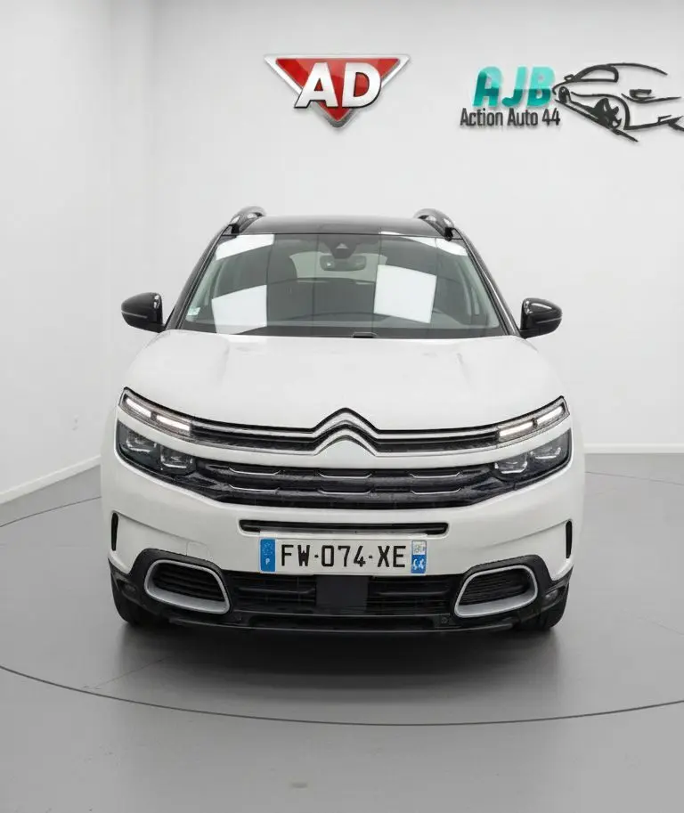 Vue frontale d'un Citroën C5 Aircross blanc nacré avec toit noir et calandre distinctive en studio.