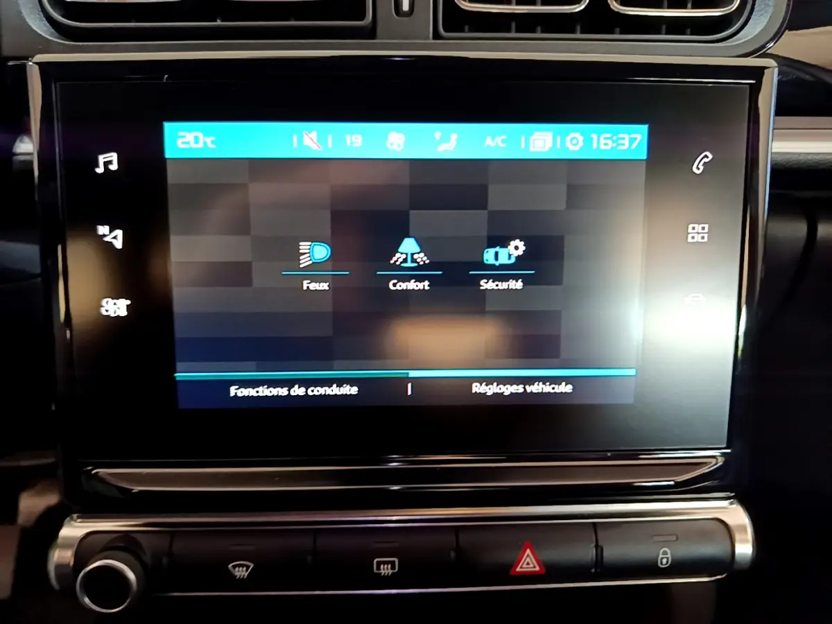 Écran tactile central affichant les réglages de conduite dans l'habitacle noir d'une Citroën C3 blanche de 2019.