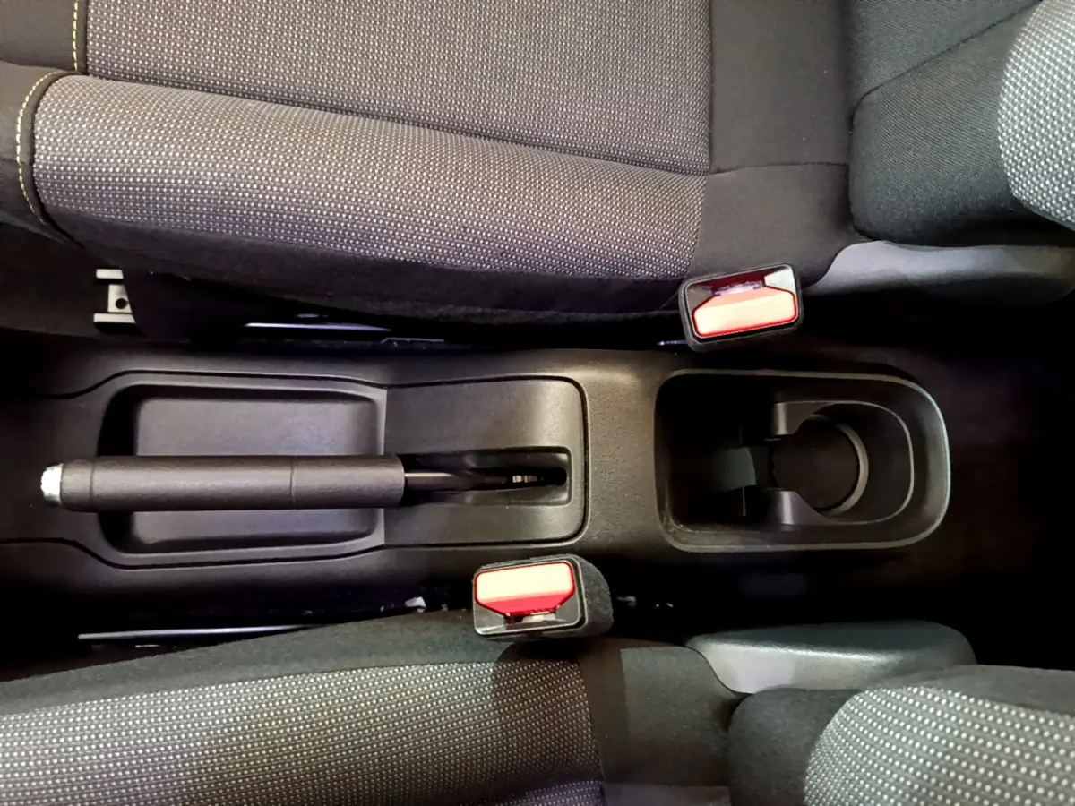 Vue plongeante sur la console centrale noire et les sièges tissu gris de la Citroën C3 blanche de 2019