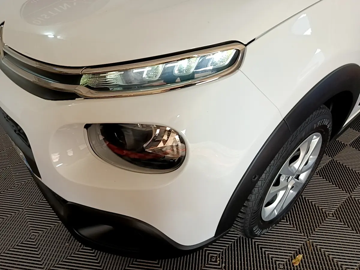 Gros plan sur l'avant droit blanc d'une Citroën C3 2019, mettant en valeur ses phares LED et la jante alliage.