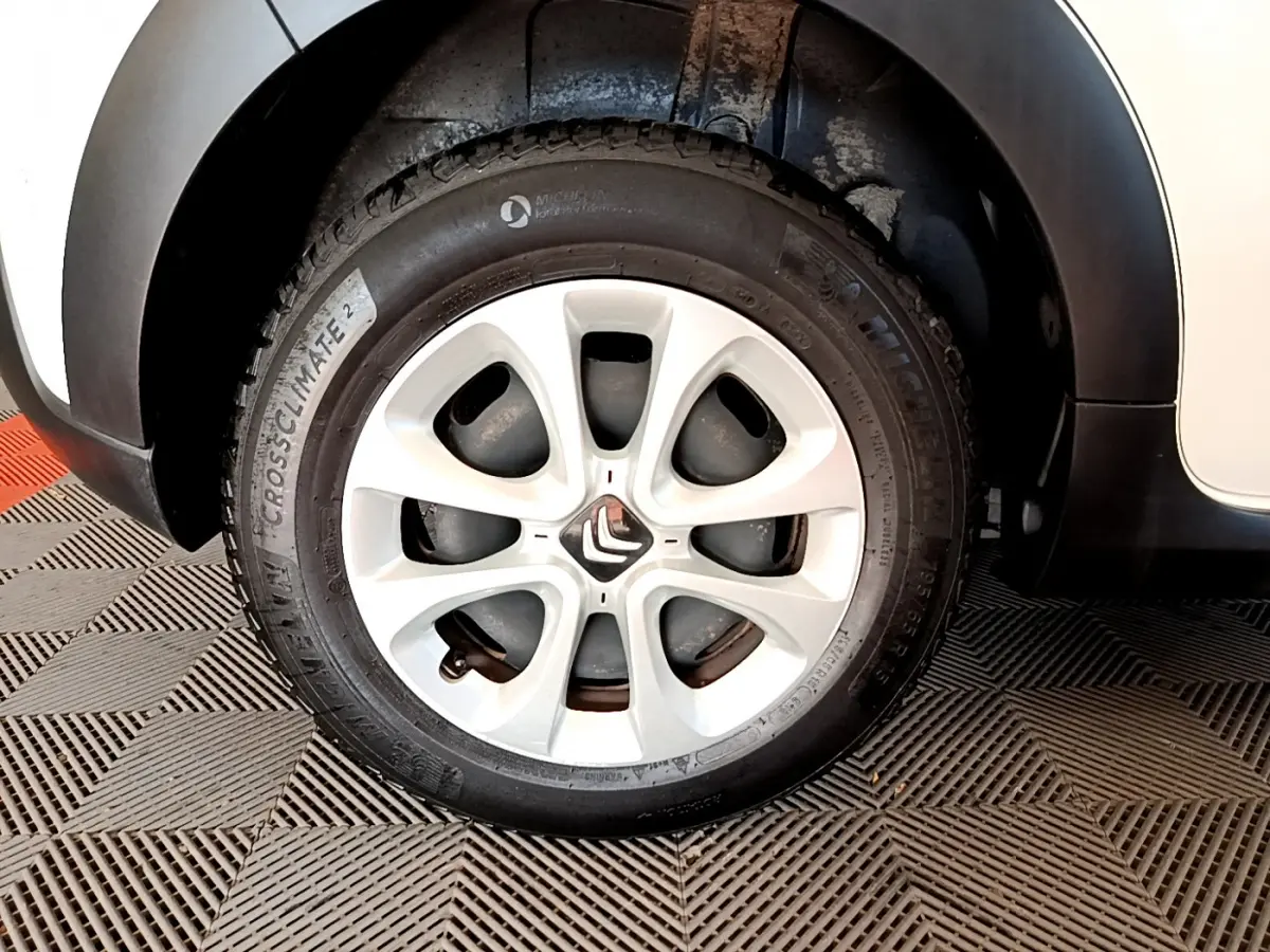 Gros plan sur la roue avant droite blanche d'une Citroën C3 2019, avec jante alliage et logo Citroën central.