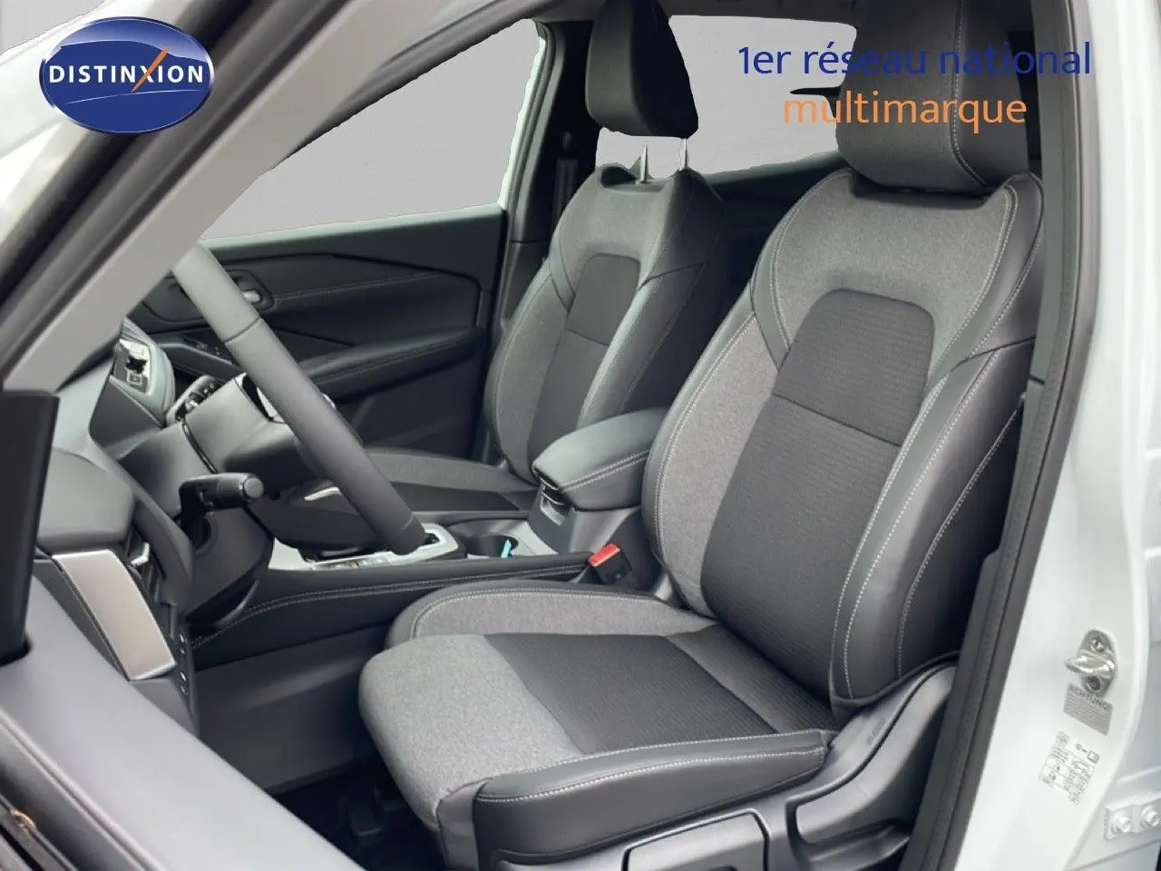 Vue intérieure côté conducteur du Nissan Qashqai blanc nacré, sièges tissu noir et gris avec surpiqûres blanches.