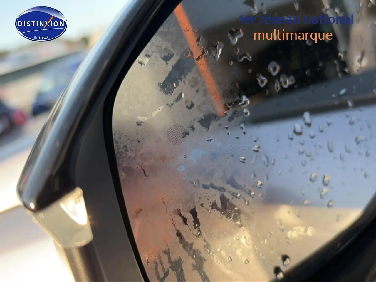 Rétroviseur côté gauche d’un Peugeot 3008 gris 2025 avec gouttes d’eau et clignotant intégré allumé.