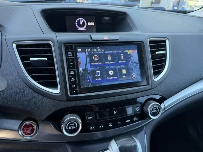 Vue intérieure du tableau de bord du Honda CR-V 2017, avec écran tactile central et commandes climatisation visibles.