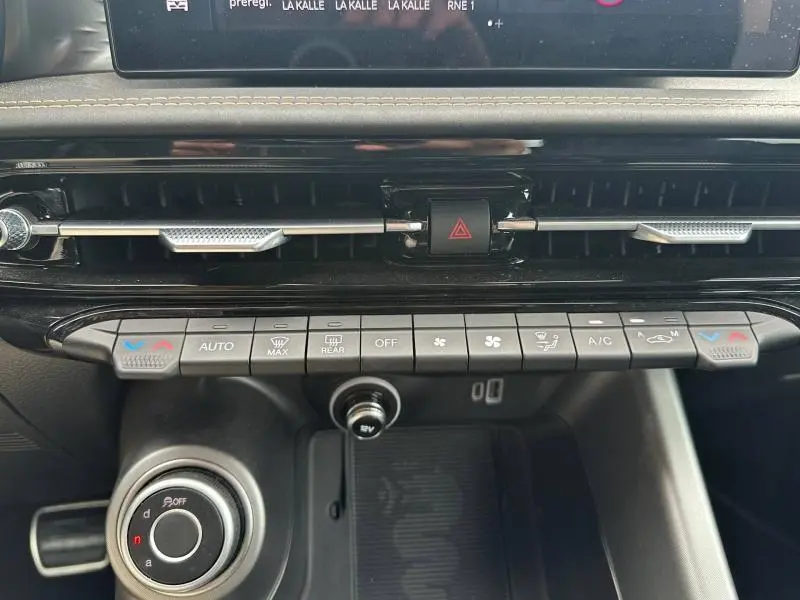 Gros plan sur la console centrale de l'Alfa Romeo Tonale 1.5 Hybrid 130ch Sprint, avec commandes climatisation et bouton hazard.