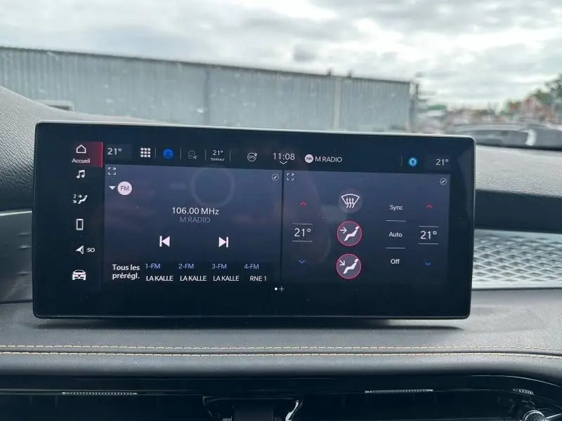 Écran tactile central de l'Alfa Romeo Tonale blanc Monterosa, affichant la radio et la climatisation en vue frontale.