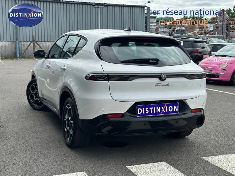 Vue 3/4 arrière droite d'une Alfa Romeo Tonale blanche Monterosa Pastel avec feux arrière LED et jantes alu noires.