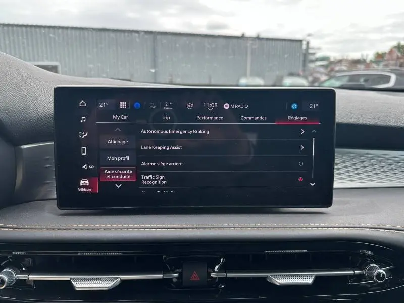 Écran tactile central affichant les réglages d’aide à la conduite de l’Alfa Romeo Tonale 1.5 Hybrid blanc, vue intérieure frontale.