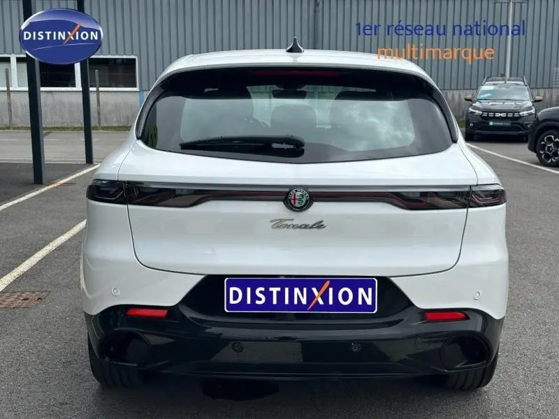 Vue arrière d'une Alfa Romeo Tonale 1.5 Hybrid 130ch Sprint blanche Monterosa Pastel avec diffuseur noir et feux arrière LED.
